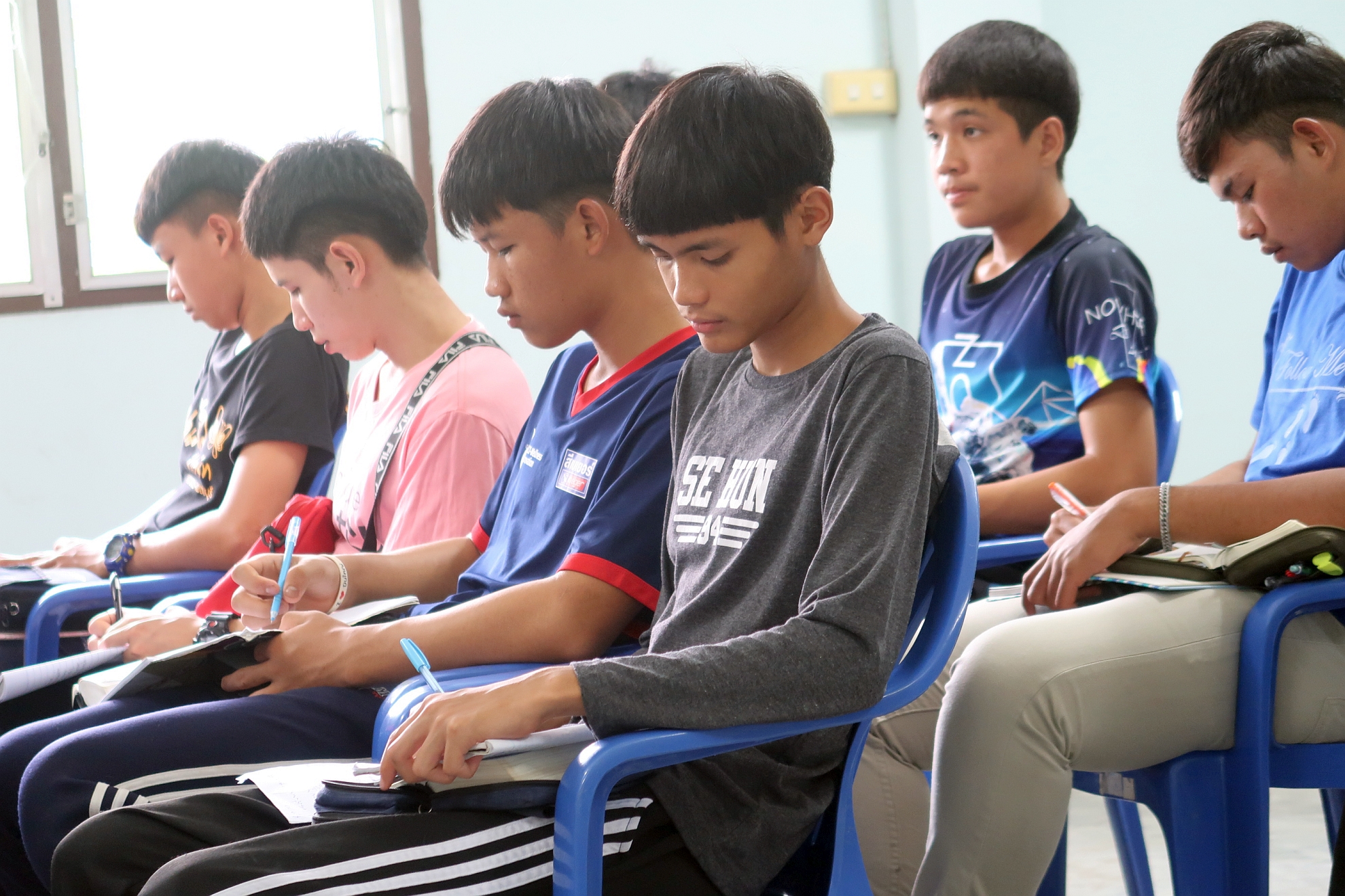 騰縣新天學校學生在崇拜中寫筆記